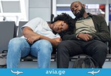 აეროპორტი, როგორც თავგადასავალი: როგორ ვაქციოთ ფრენებს შორის ლოდინი სასიამოვნო დასვენებად Two tired travelers sleeping on chairs in an airport terminal waiting area with backpacks.