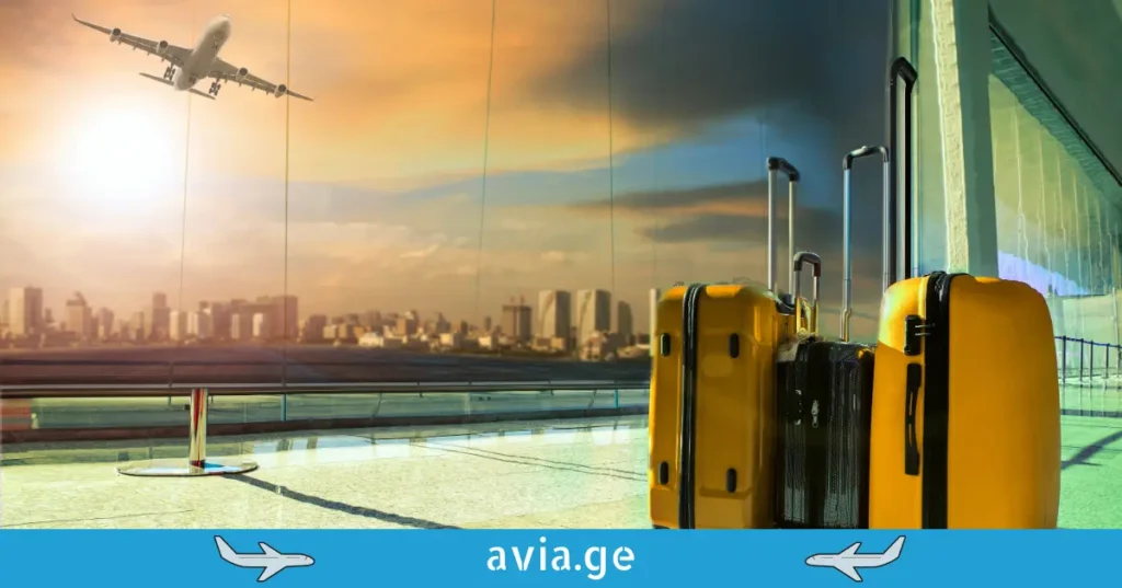 Yellow suitcases at airport terminal with an airplane taking off during sunset.