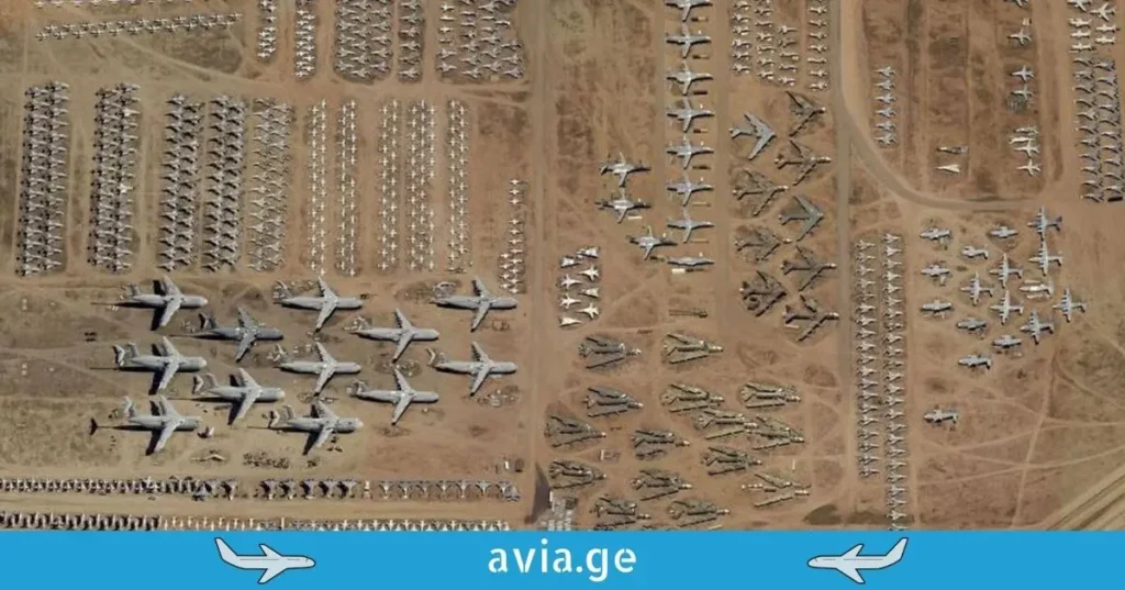 Aerial view of a massive aircraft boneyard with hundreds of airplanes parked in rows in the desert.