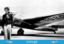 5 ყველაზე უცნაური ფაქტი ავიაციის ისტორიიდან Black and white historical photo of Amelia Earhart posing in front of the wing of her twin-engine Lockheed Electra aircraft, registration NR16020.