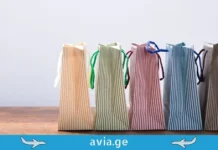 ევროპის 5 საუკეთესო ქალაქი შოპინგისთვის, სადაც ავიაბილეთები ყველაზე იაფია Row of colorful striped shopping bags on a wooden surface with avia.ge travel branding