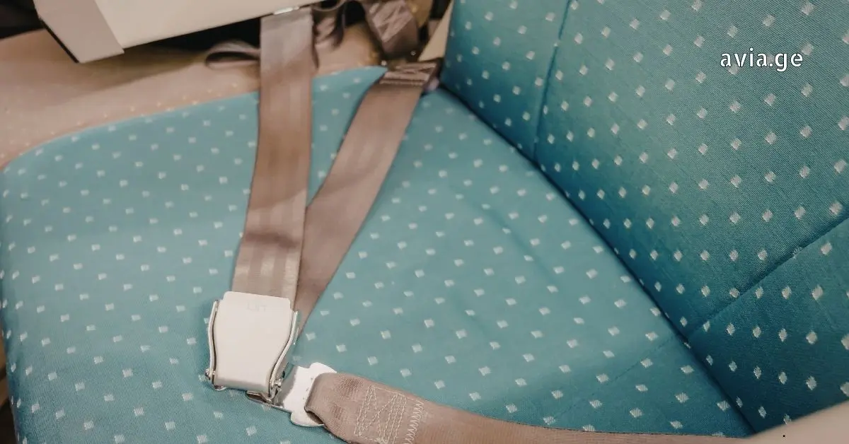 Airplane seat belt on a patterned seat.