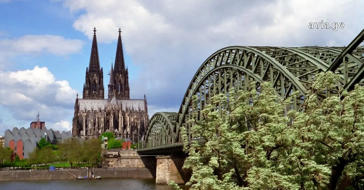 View across the Rhine River of the historic Cologne Cathedral and Hohenzollern Bridge.
