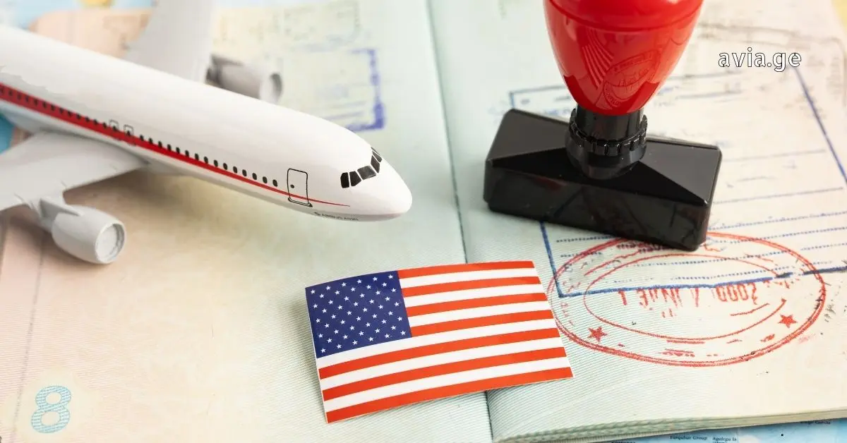 A model airplane, a small US flag sticker, and a red passport stamp are placed on an open passport page.