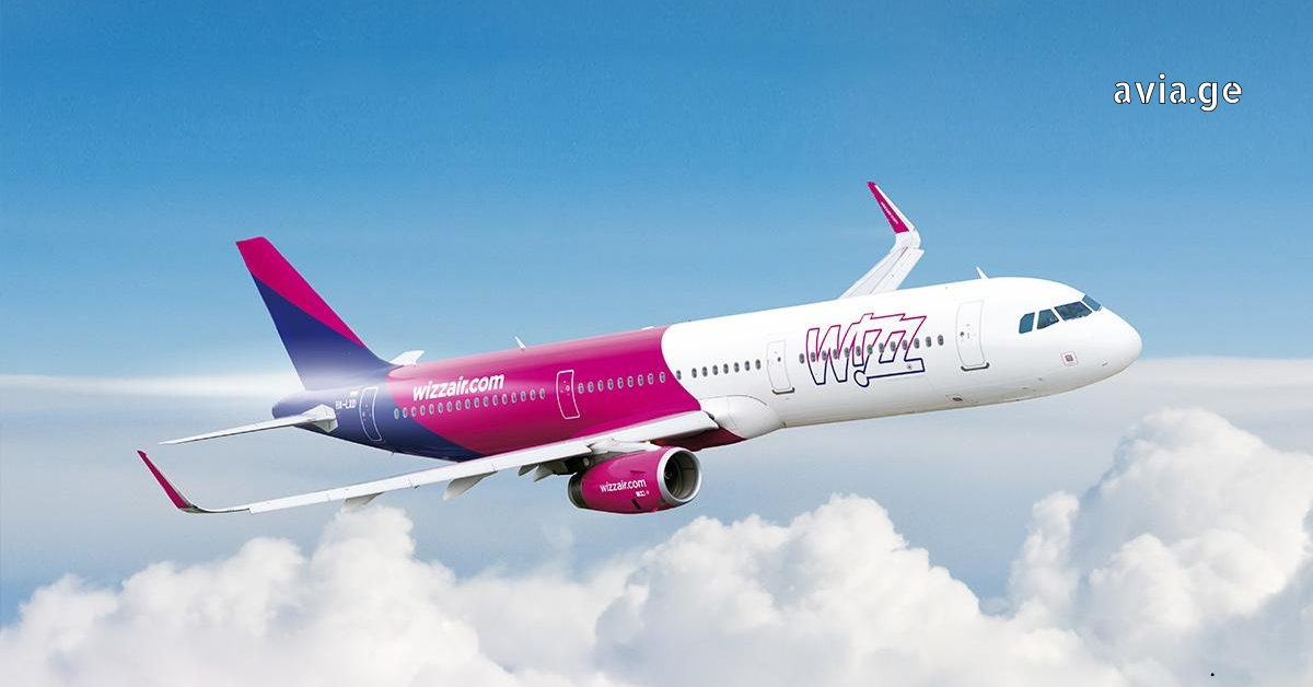 Wizz Air Airbus aircraft soaring through a blue sky above white clouds.