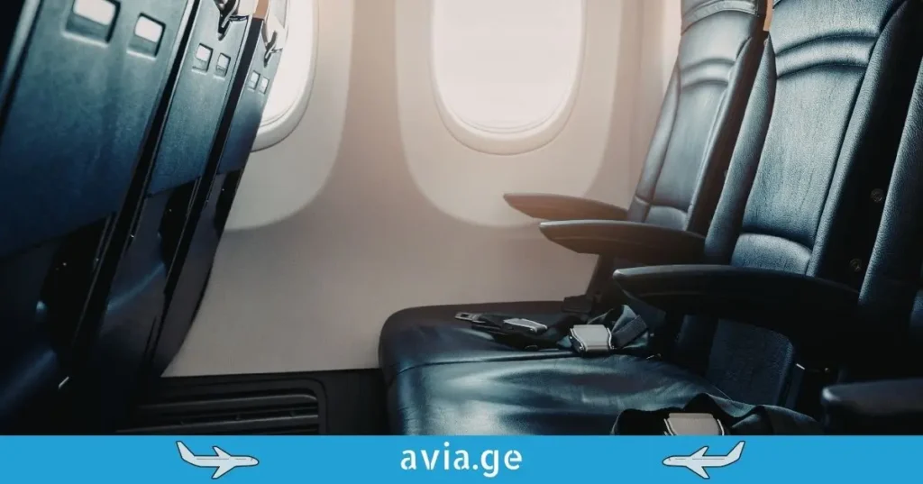 Empty economy class airplane seats with aisle armrest by the window