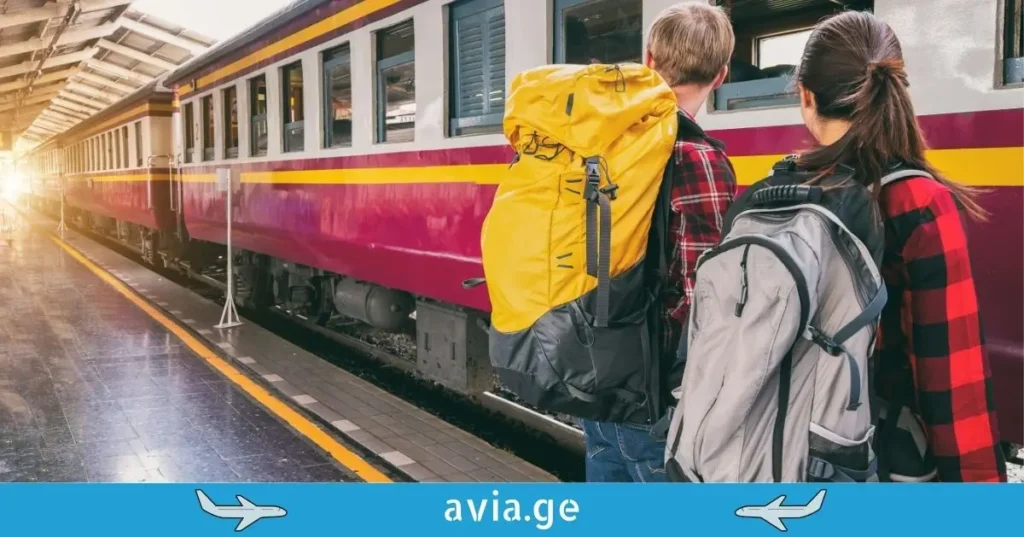 Two backpackers on a train station platform