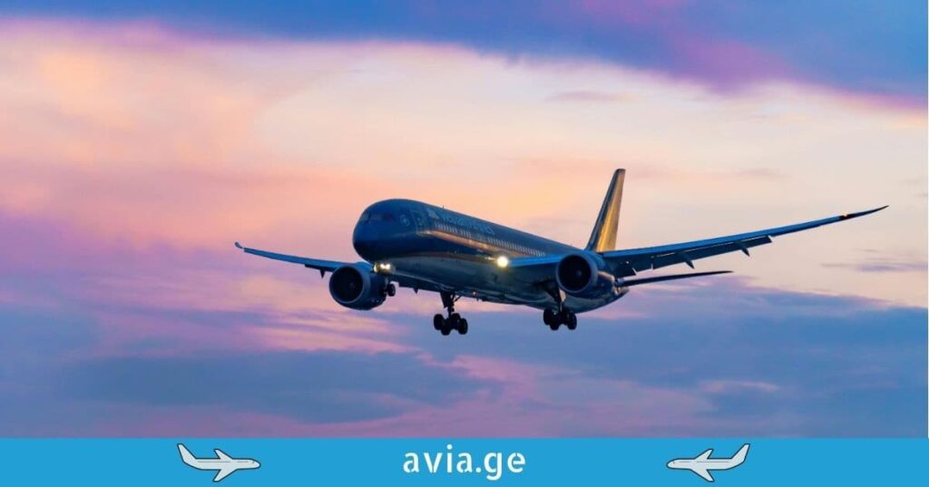 Airplane landing at sunset with a purple and pink sky background