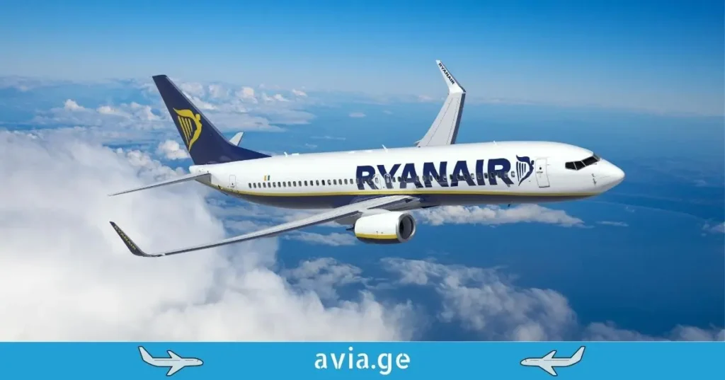 A Ryanair Boeing 737 airplane flying through clouds in a blue sky.