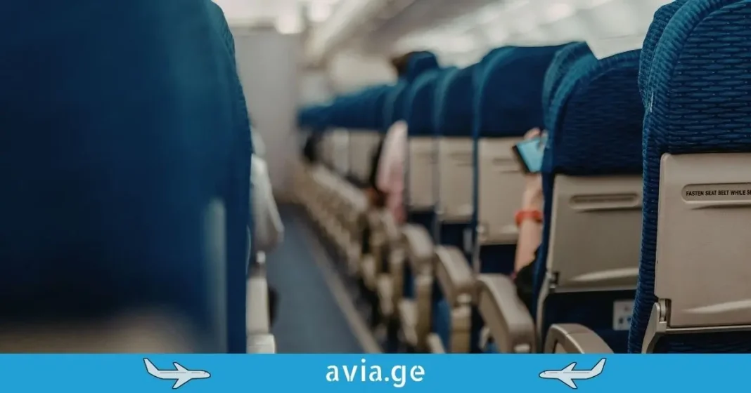 Airplane Cabin Aisle and Seating - Avia.ge Perspective view of blue airplane seat rows in a cabin with avia.ge logo banner.