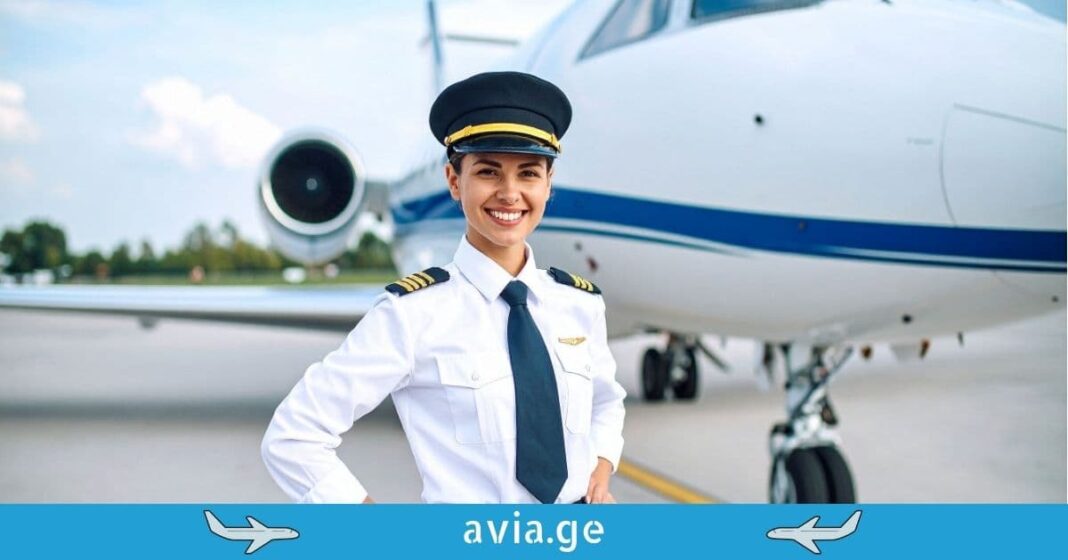 Female Airline Pilot smiling at airport Female pilot in professional uniform and cap smiling in front of a white private jet on an airport runway