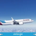გერმანია კიდევ უფრო ახლოსაა: Eurowings-ი თბილისი-კიოლნის პირდაპირ რეისებს იწყებს An inflight view of a white and purple Eurowings commercial airplane flying above the clouds.
