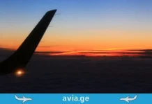 საავიაციო კრიზისი: აზია საწვავის დეფიციტის მოლოდინშია, ევროპული გიგანტები სტრატეგიას ცვლიან Airplane winglet with lights above clouds at sunset, avia.ge logo.