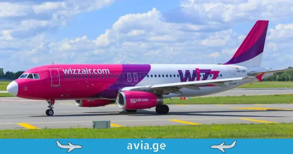 Side view of a Wizz Air Airbus A320 taxiing on the runway under a blue sky.