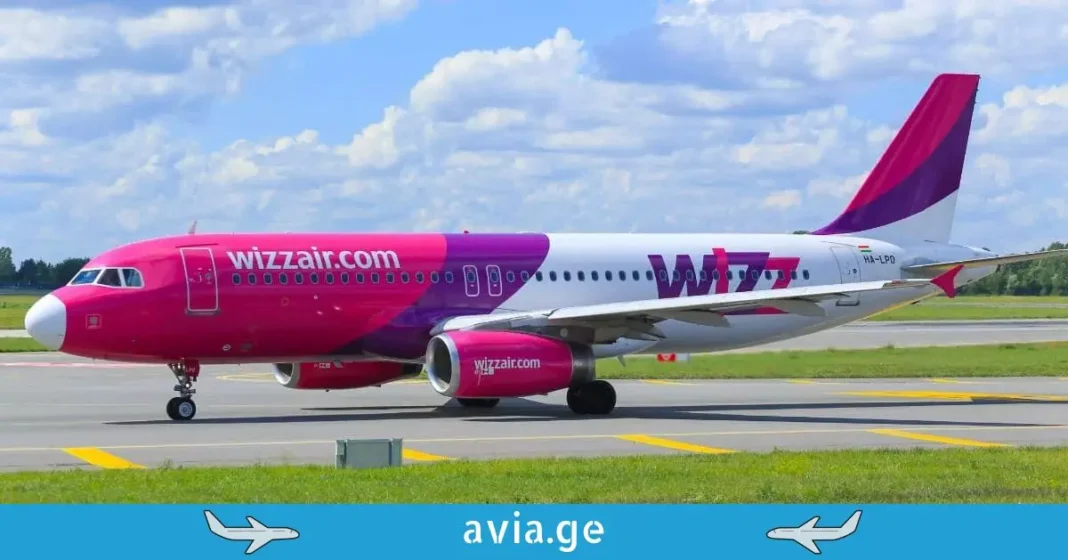 Wizz Air Aircraft Taxiing at the Airport Side view of a Wizz Air Airbus A320 taxiing on the runway under a blue sky.