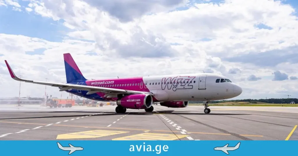Wizz Air airplane on a runway under a cloudy sky.