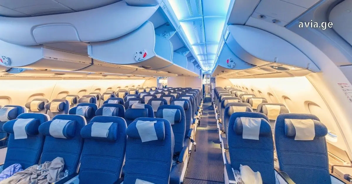 Airplane cabin with blue seats and overhead bins