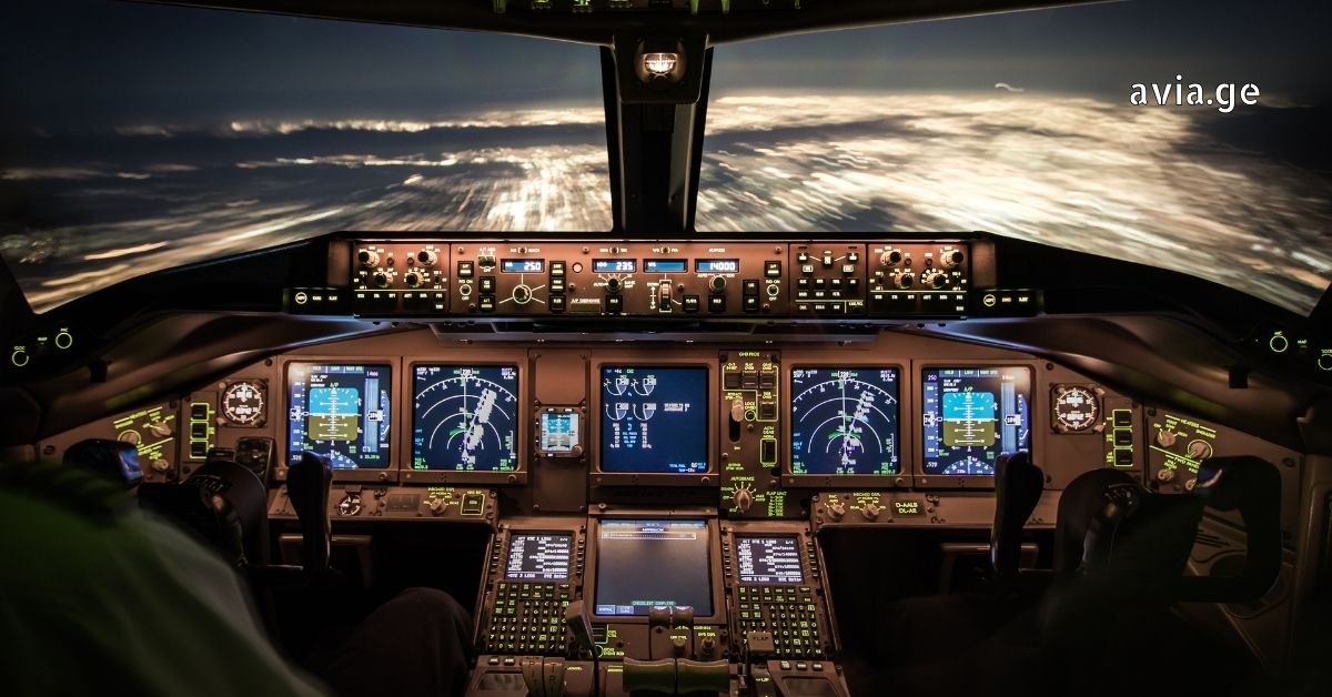 Modern airplane cockpit at night with glowing controls