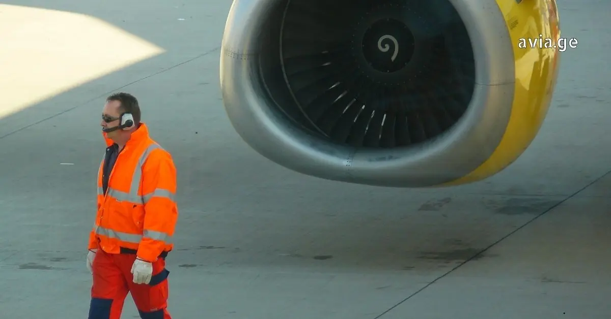აეროპორტის თანამშრომელი თვითმფრინავის ძრავთან