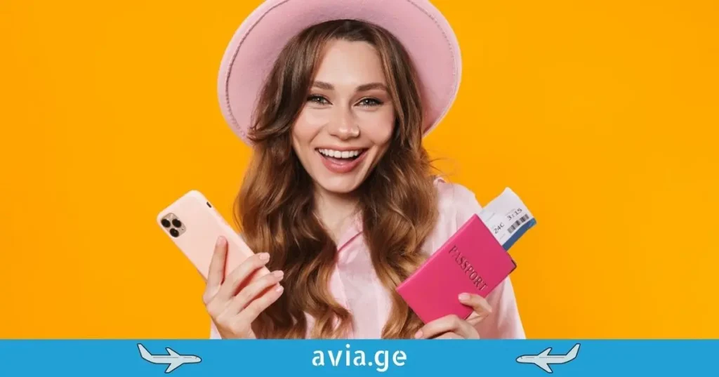 მომღიმარი ქალი პასპორტით და სმარტფონით