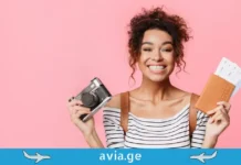 საჩუქარი ციდან: რეისი, სადაც ყველა მგზავრი „მილიონერი“ გახდა ბედნიერი მოგზაური ქალი კამერით და პასპორტით ვარდისფერ ფონზე -